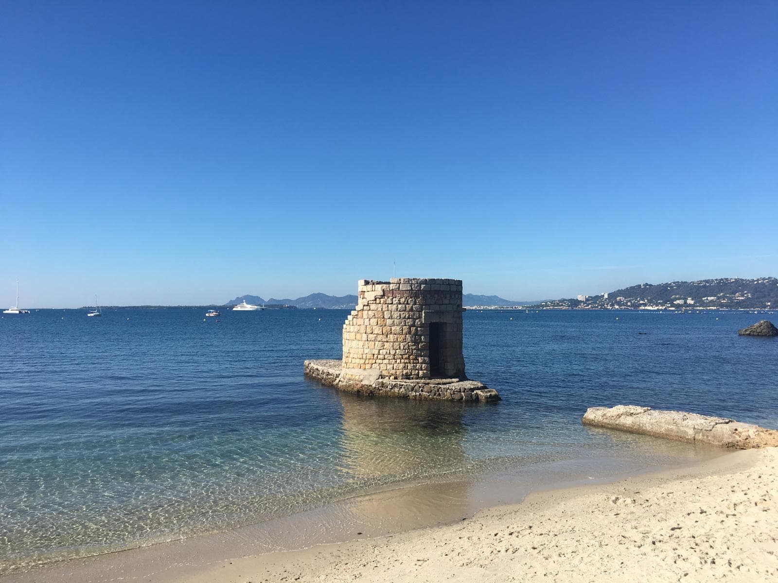 Golden beach with ancient tower on the sea